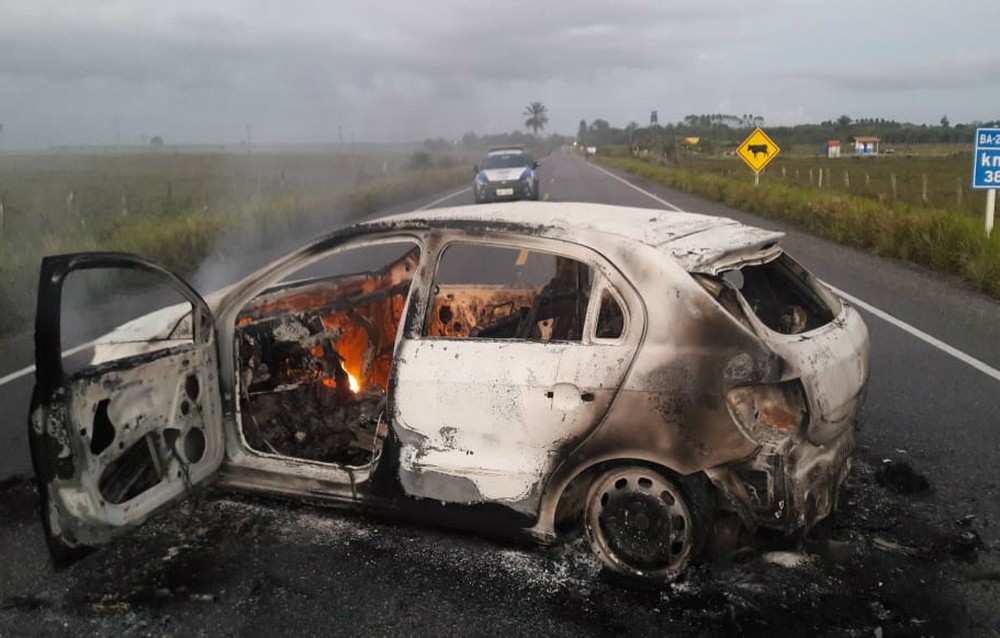 Grupo atravessou carro incendiado na BA-275, que dá acesso à cidade — Foto: Crisney Souza Dias/Site +BN